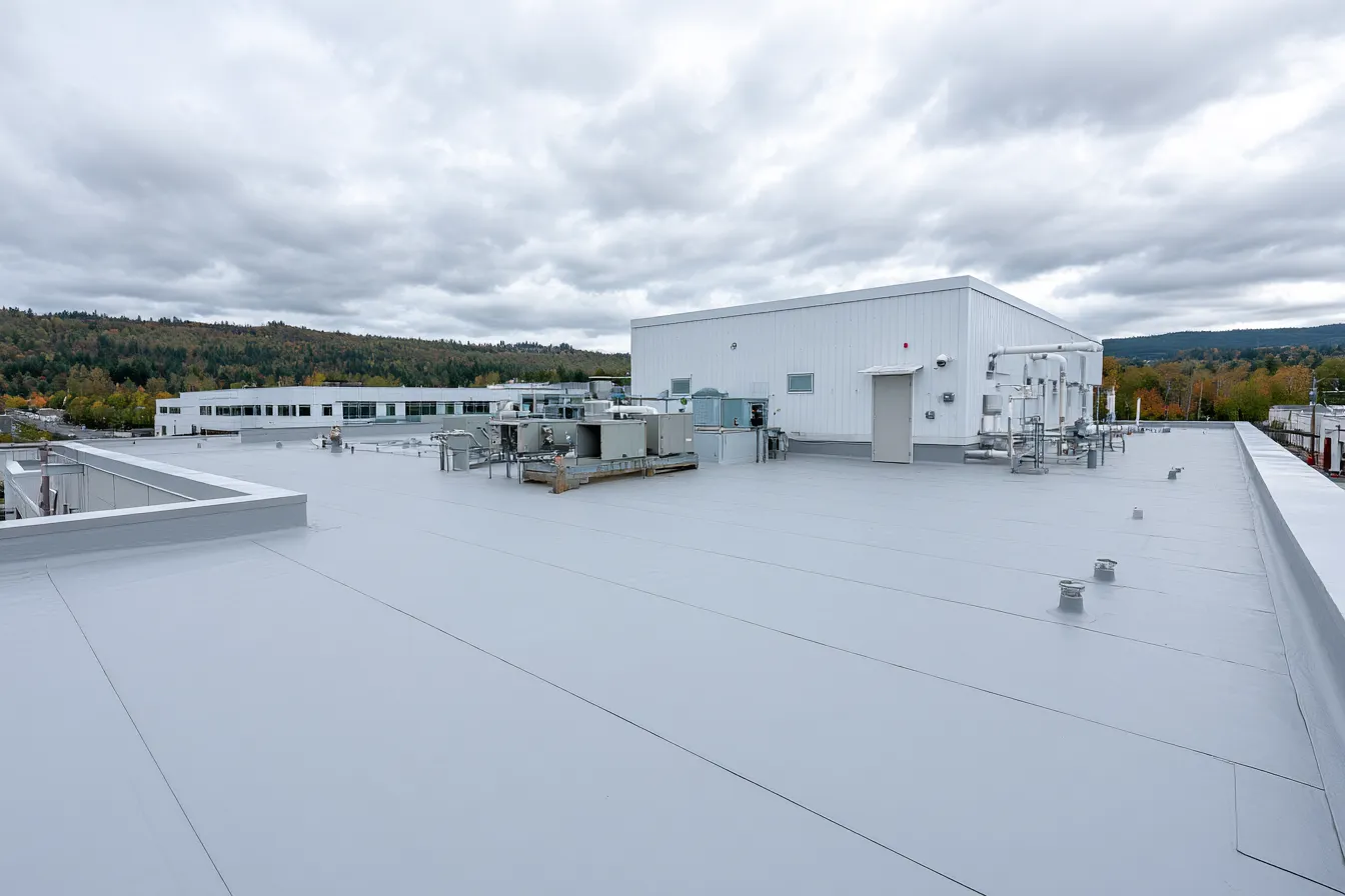 Gray flat roof with mechanical equipment under an overcast sky