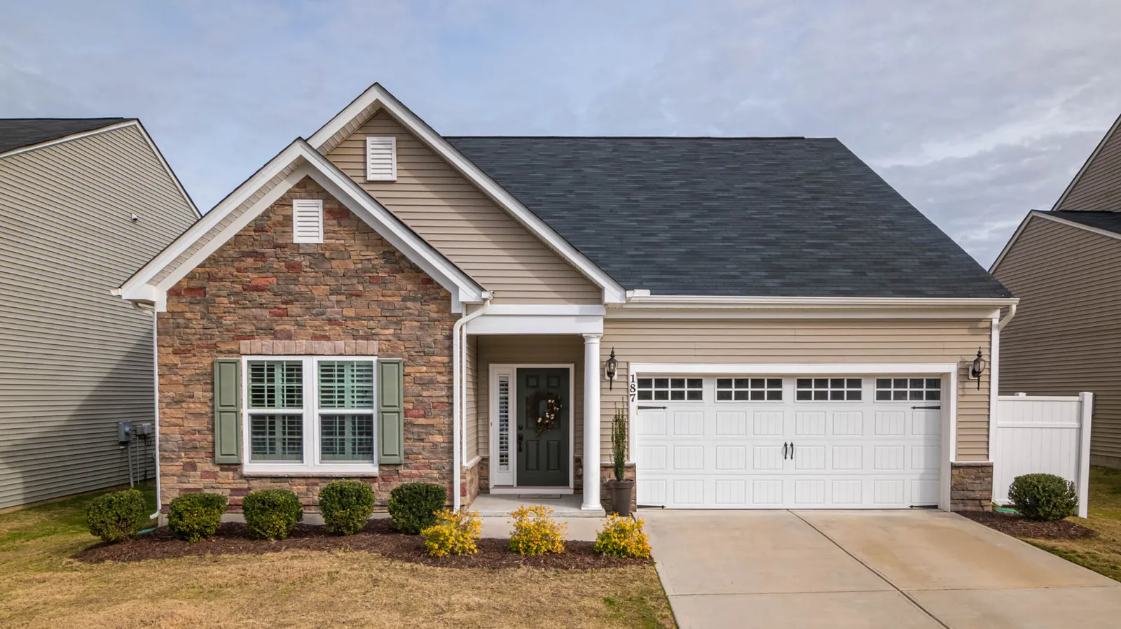 Dark gray asphalt shingle roof on a stone accented ranch home
