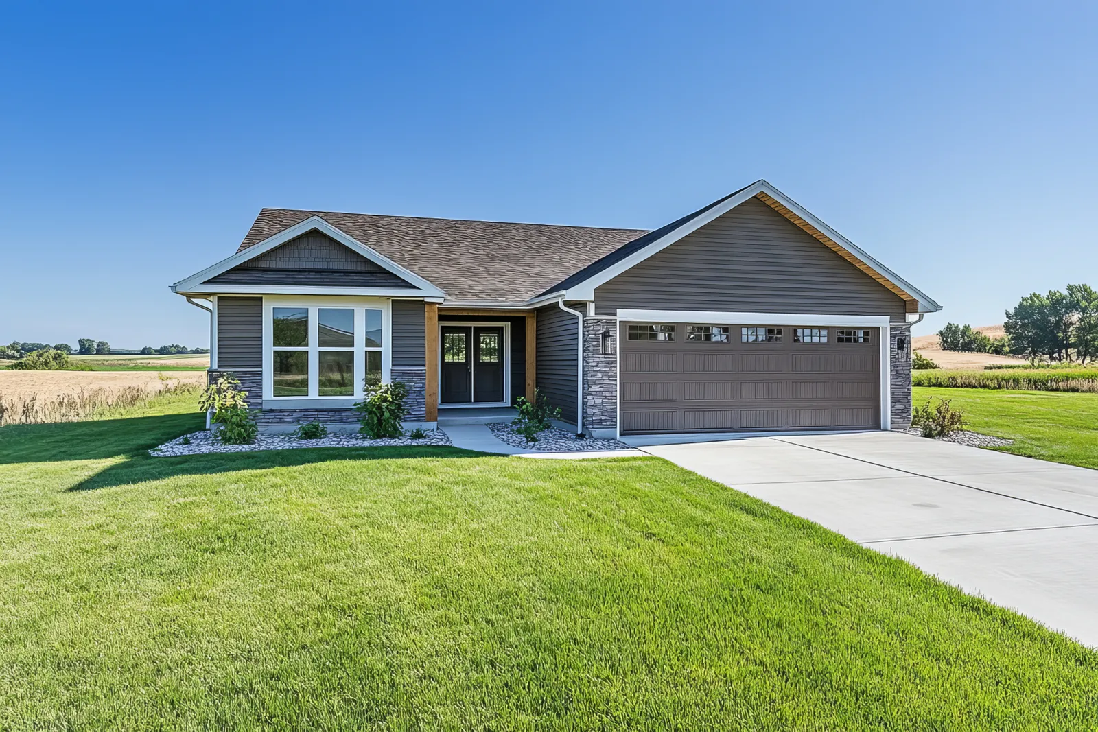 Ranch home with brown shingle roof and stone accented garage