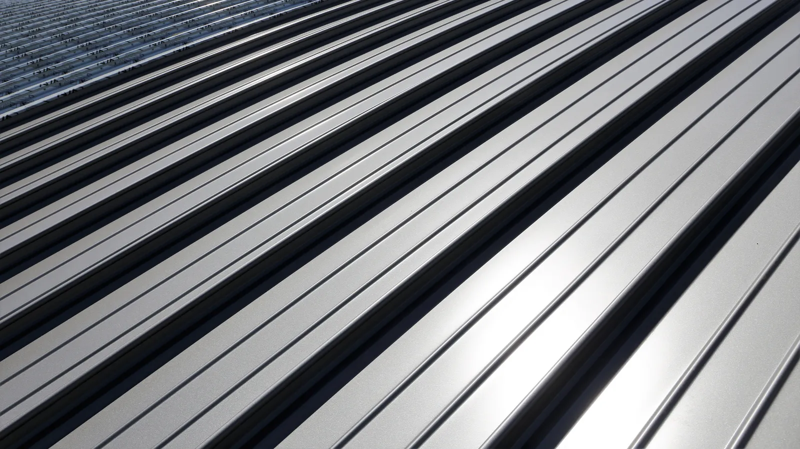 Reflected sunlight on panels of a standing seam metal roof