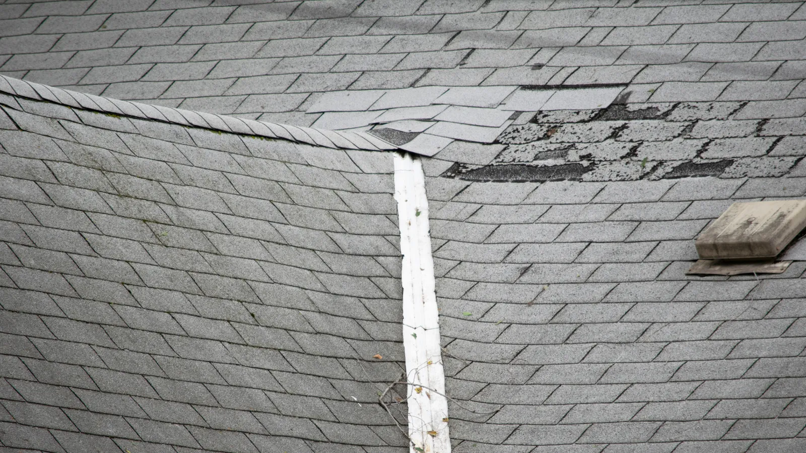 Weathered gray roof showing creased and broken shingle tabs